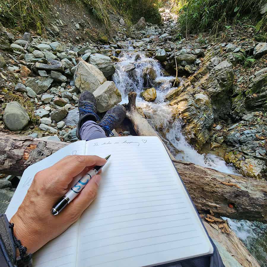 Writing in a journal in the woods